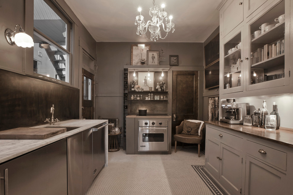 Immagine di una cucina ad U design chiusa con lavello sottopiano, ante con riquadro incassato, ante grigie e elettrodomestici in acciaio inossidabile