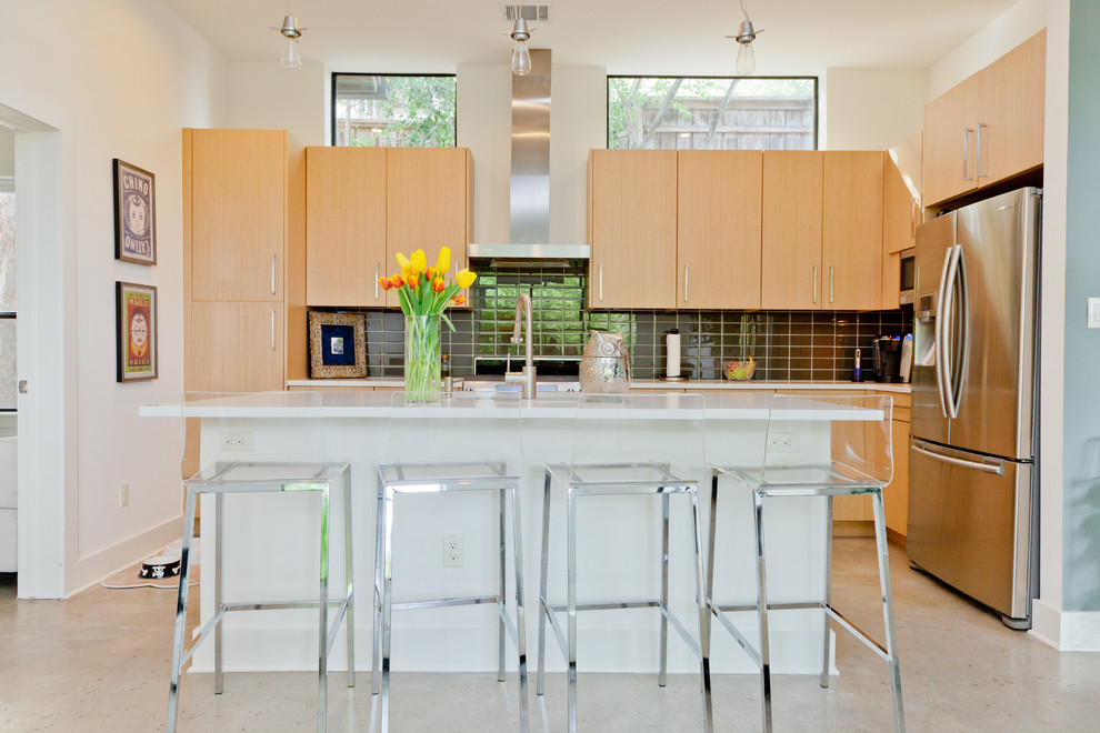 Exempel på ett modernt kök, med svart stänkskydd och rostfria vitvaror