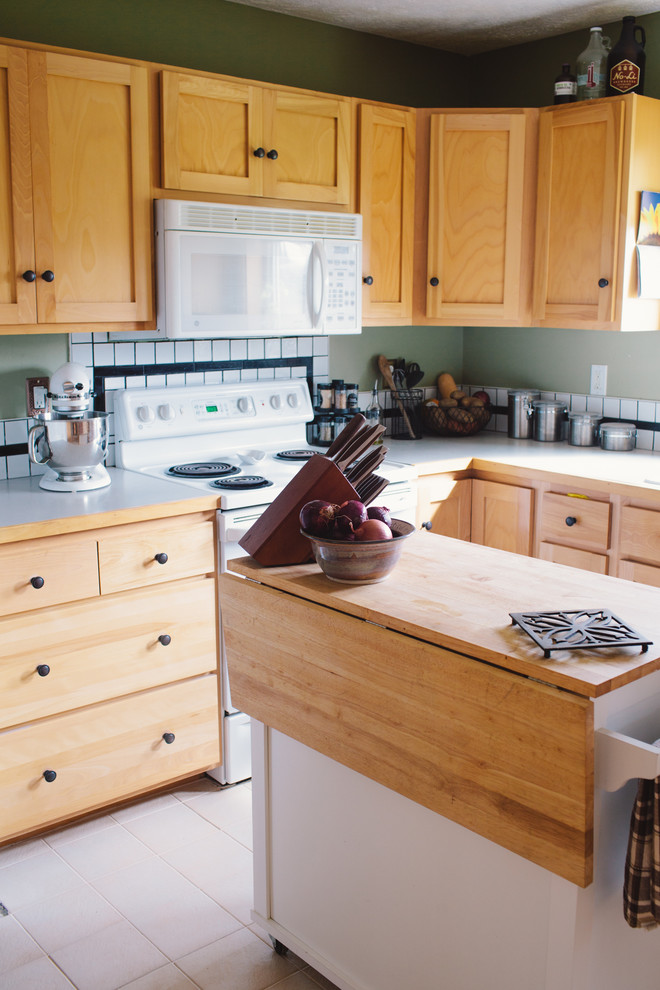 シアトルにある低価格の小さなカントリー風のおしゃれなキッチン (ダブルシンク、白いキッチンパネル、磁器タイルのキッチンパネル、白い調理設備、無垢フローリング) の写真