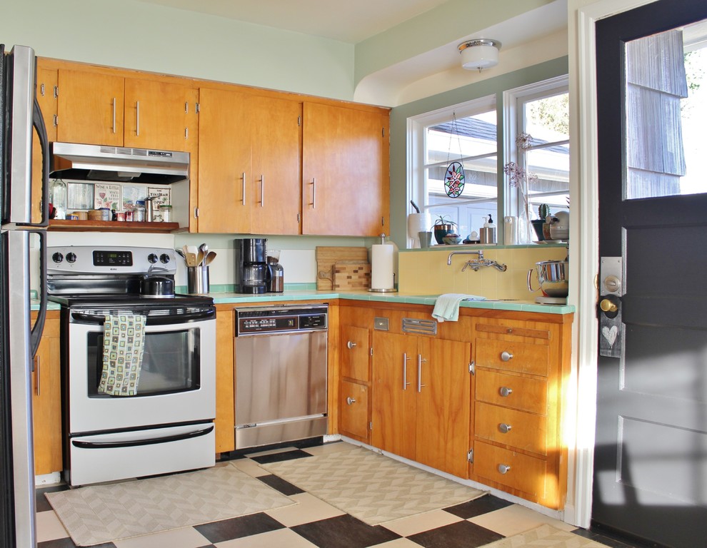 ポートランドにあるエクレクティックスタイルのおしゃれなキッチン (フラットパネル扉のキャビネット、中間色木目調キャビネット、タイルカウンター、黄色いキッチンパネル、セラミックタイルのキッチンパネル、シルバーの調理設備、緑のキッチンカウンター) の写真