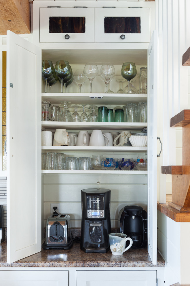 Modelo de cocina costera con armarios estilo shaker, puertas de armario blancas y encimera de granito