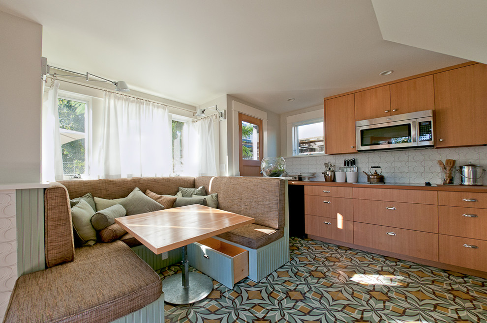 Moderne Küche mit flächenbündigen Schrankfronten, hellbraunen Holzschränken, Küchenrückwand in Weiß und Rückwand aus Zementfliesen in Portland