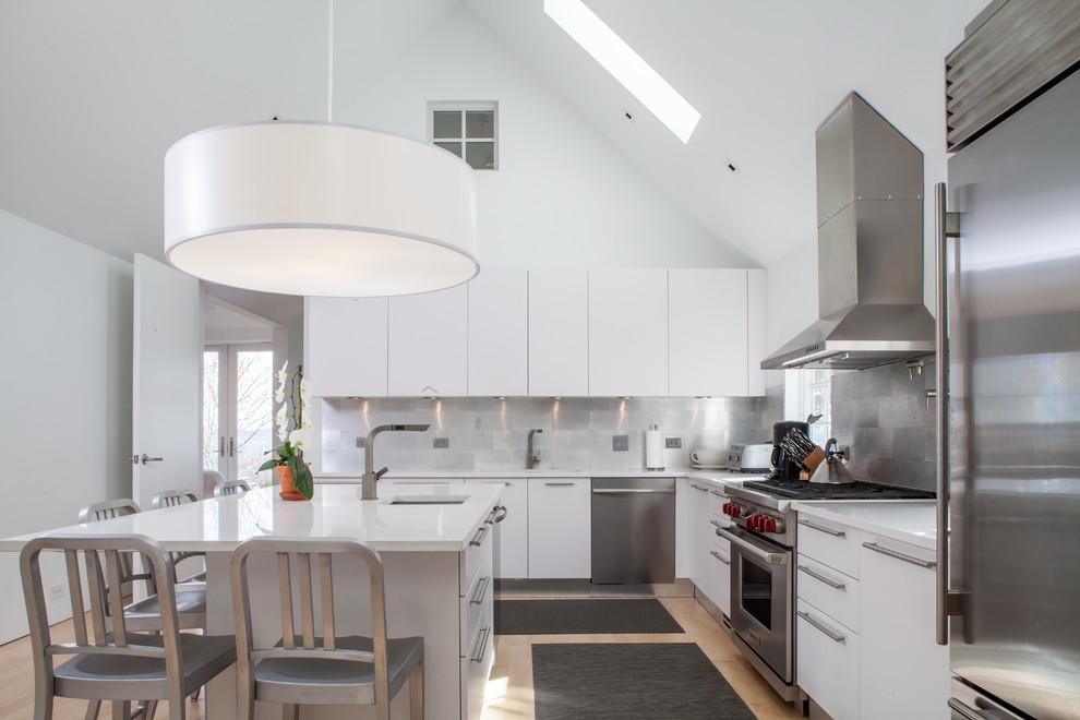 На фото: угловая кухня в стиле кантри с врезной мойкой, плоскими фасадами, белыми фасадами и техникой из нержавеющей стали