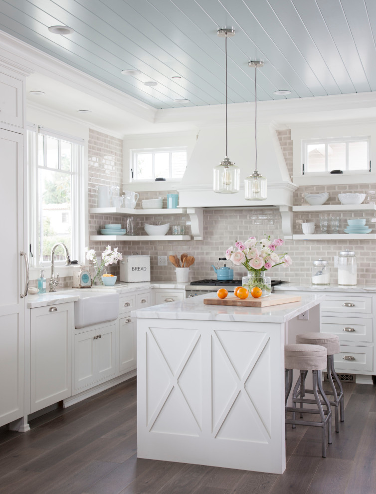 This is an example of a beach style l-shaped kitchen in San Diego with shaker cabinets, white cabinets, grey splashback, mosaic tiled splashback, dark hardwood flooring, an island, brown floors and a timber clad ceiling.