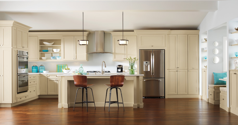 Inspiration for a contemporary l-shaped kitchen in Orange County with a submerged sink, shaker cabinets, yellow cabinets, stainless steel appliances, dark hardwood flooring and an island.