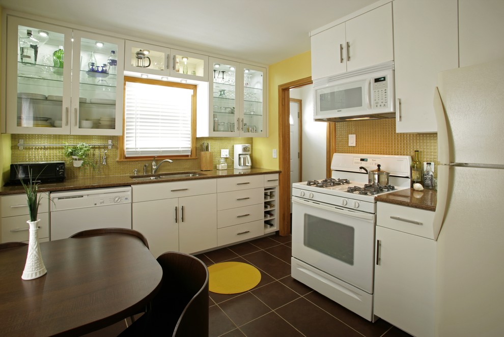 Eklektisk inredning av ett kök, med luckor med glaspanel, vita vitvaror, vita skåp, gult stänkskydd och stänkskydd i mosaik