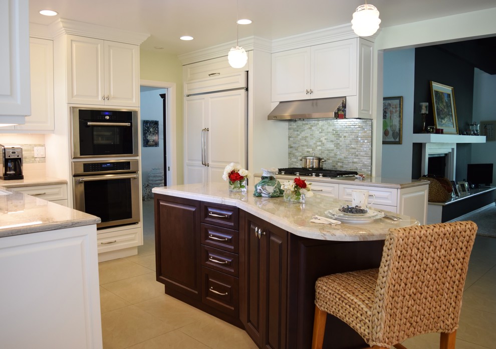 This is an example of a medium sized classic u-shaped kitchen/diner in Los Angeles with white cabinets, quartz worktops, glass tiled splashback, stainless steel appliances, porcelain flooring and an island.