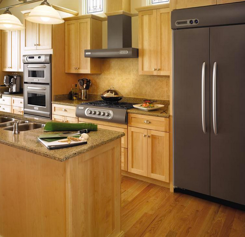 Bild på ett mellanstort amerikanskt kök, med en trippel diskho, skåp i shakerstil, skåp i ljust trä, granitbänkskiva, beige stänkskydd, stänkskydd i keramik, rostfria vitvaror, mellanmörkt trägolv, en köksö och brunt golv