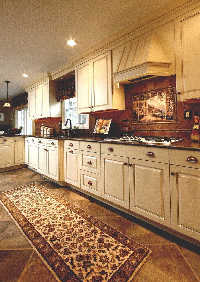 Example of a mid-sized classic u-shaped ceramic tile open concept kitchen design in New York with an undermount sink, raised-panel cabinets, white cabinets, granite countertops, brown backsplash, terra-cotta backsplash, a peninsula and paneled appliances