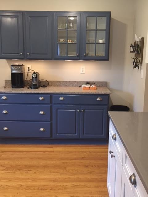 Medium sized traditional u-shaped enclosed kitchen in Louisville with a belfast sink, shaker cabinets, blue cabinets, composite countertops, white splashback, ceramic splashback, stainless steel appliances, medium hardwood flooring and brown floors.