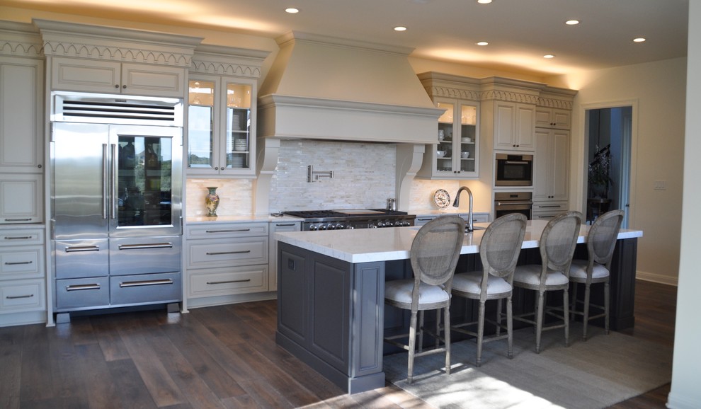 Inspiration for a large transitional single-wall dark wood floor eat-in kitchen remodel in Austin with raised-panel cabinets, beige cabinets, metallic backsplash, matchstick tile backsplash, stainless steel appliances and an island