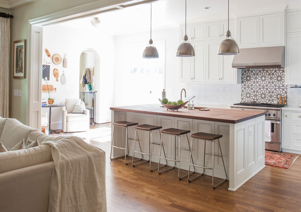Inspiration for a mid-sized transitional l-shaped dark wood floor and brown floor open concept kitchen remodel in Charlotte with an undermount sink, white cabinets, wood countertops, stainless steel appliances, an island, recessed-panel cabinets and multicolored backsplash