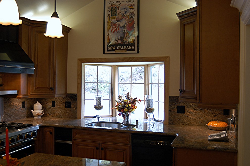 Example of a large classic l-shaped medium tone wood floor eat-in kitchen design in San Francisco with a drop-in sink, raised-panel cabinets, medium tone wood cabinets, granite countertops, beige backsplash, stone slab backsplash, stainless steel appliances and an island