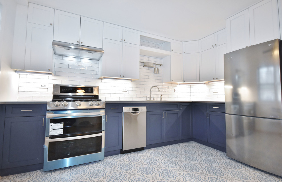 Foto på ett mellanstort funkis grå kök, med en nedsänkt diskho, skåp i shakerstil, blå skåp, bänkskiva i kvarts, rött stänkskydd, stänkskydd i tunnelbanekakel, rostfria vitvaror, klinkergolv i keramik och flerfärgat golv