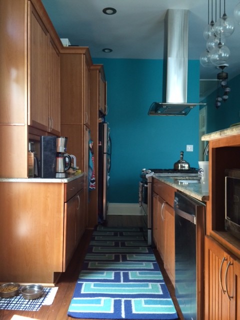 Exemple d'une cuisine américaine éclectique en L et bois brun de taille moyenne avec îlot, un placard à porte affleurante, un plan de travail en granite, un électroménager en acier inoxydable, un évier encastré et un sol en bois brun.
