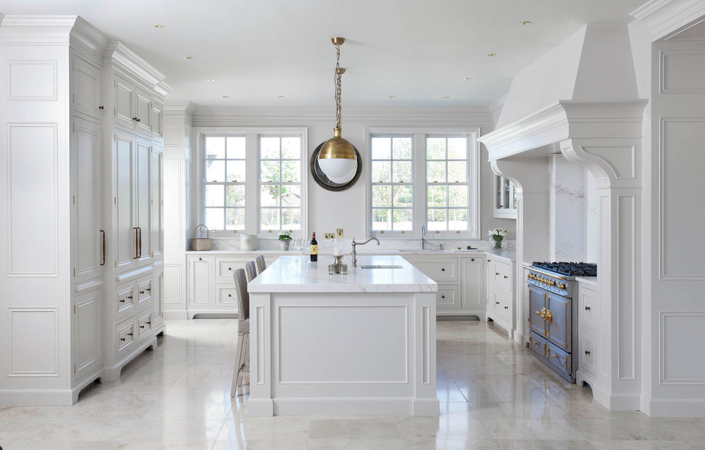Idéer för ett stort klassiskt gul kök, med en nedsänkt diskho, luckor med profilerade fronter, vita skåp, marmorbänkskiva, vitt stänkskydd, stänkskydd i marmor, rostfria vitvaror, klinkergolv i porslin, en köksö och beiget golv