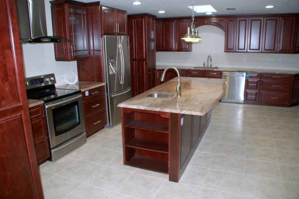Bild på ett mellanstort vintage kök, med en undermonterad diskho, luckor med upphöjd panel, skåp i mellenmörkt trä, granitbänkskiva, vitt stänkskydd, rostfria vitvaror och klinkergolv i porslin