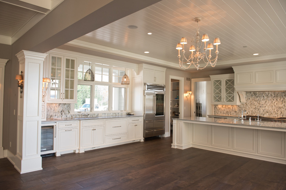Bild på ett mycket stort lantligt kök, med en rustik diskho, skåp i shakerstil, vita skåp, marmorbänkskiva, flerfärgad stänkskydd, stänkskydd i mosaik, rostfria vitvaror, mörkt trägolv och en köksö