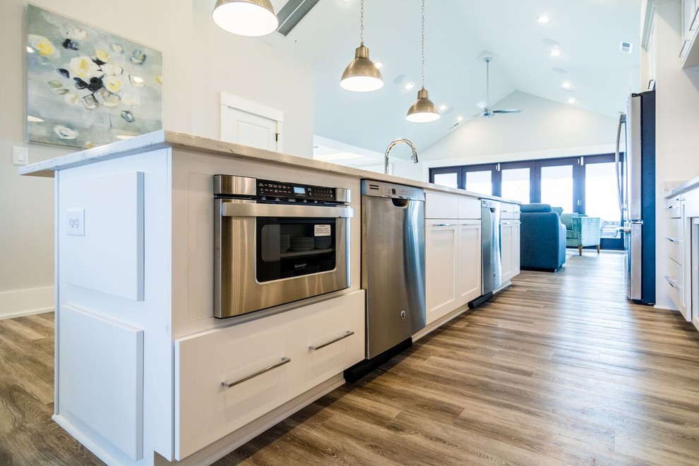 Medium sized beach style single-wall enclosed kitchen in Other with a submerged sink, shaker cabinets, white cabinets, marble worktops, grey splashback, mosaic tiled splashback, stainless steel appliances, dark hardwood flooring, an island and brown floors.