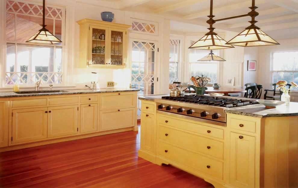 Esempio di una grande cucina american style con lavello sottopiano, ante a filo, ante gialle, top in granito e elettrodomestici da incasso