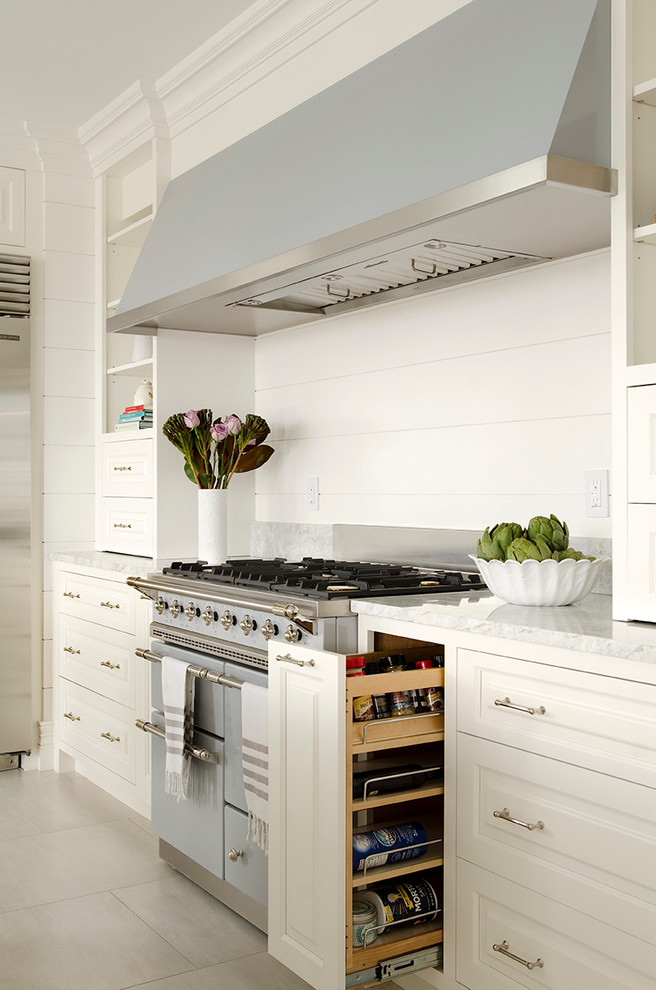 Diseño de cocina comedor clásica grande con armarios con paneles con relieve, puertas de armario blancas, electrodomésticos de colores y una isla