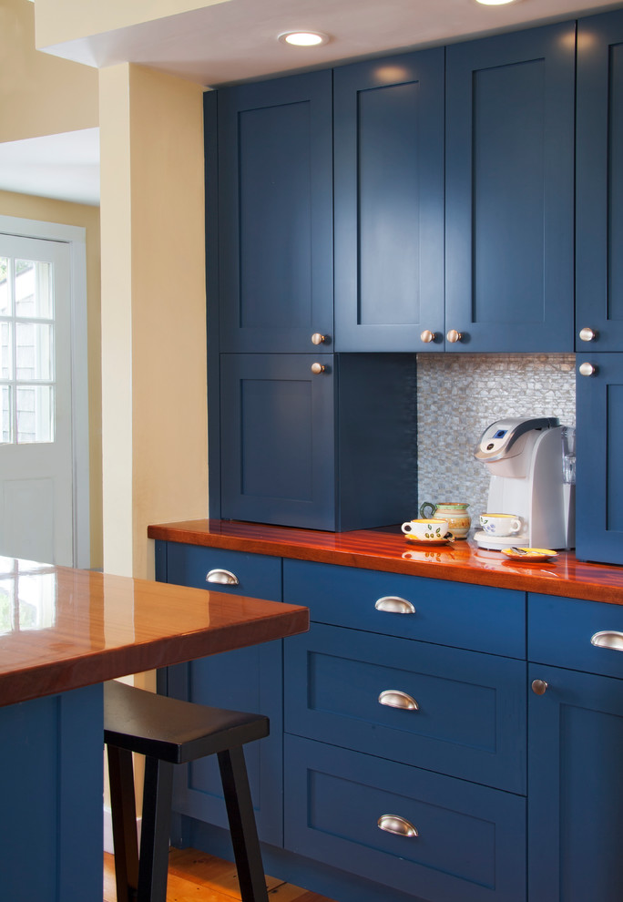 Inredning av ett klassiskt mellanstort kök, med en undermonterad diskho, skåp i shakerstil, blå skåp, träbänkskiva, vitt stänkskydd, rostfria vitvaror, mellanmörkt trägolv och en köksö
