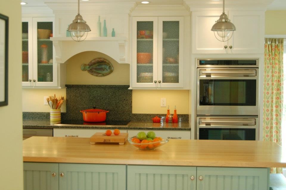 Beach style light wood floor kitchen photo in Boston with an undermount sink, recessed-panel cabinets, white cabinets, wood countertops, stone slab backsplash, stainless steel appliances and an island