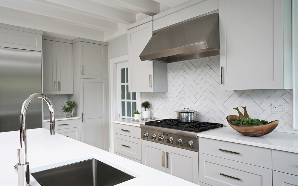 Transitional light wood floor and white floor kitchen photo with an undermount sink, beaded inset cabinets, white cabinets, quartz countertops, white backsplash, ceramic backsplash, stainless steel appliances, an island and white countertops