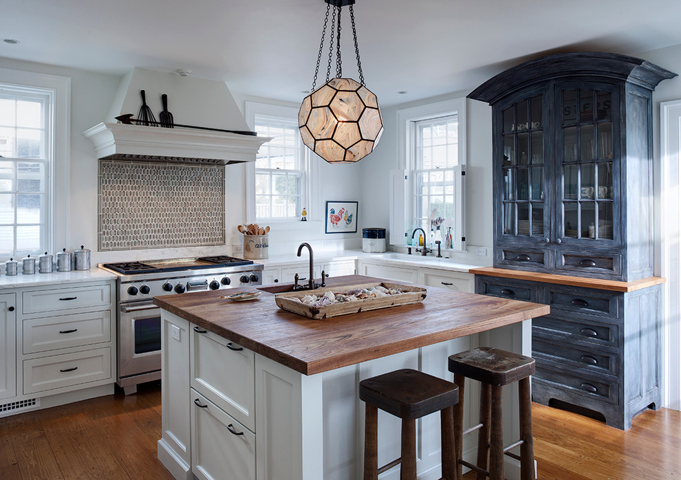 Inspiration for a transitional l-shaped kitchen remodel in Chicago with an undermount sink, recessed-panel cabinets, white cabinets, wood countertops and subway tile backsplash