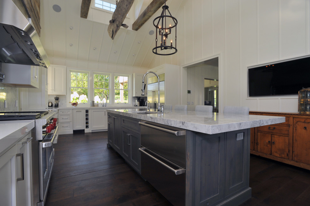Modern inredning av ett kök, med skåp i shakerstil, grå skåp, marmorbänkskiva, grått stänkskydd, stänkskydd i sten, rostfria vitvaror, målat trägolv och en köksö