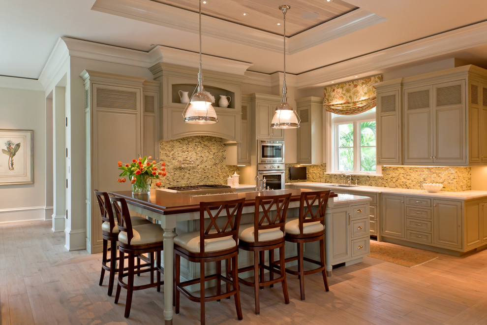 Design ideas for a large traditional l-shaped kitchen in Boston with raised-panel cabinets, green cabinets, multi-coloured splashback, an island, a submerged sink and wood worktops.