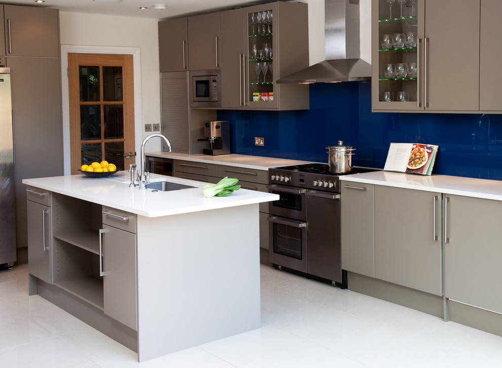 Ejemplo de cocina lineal nórdica con armarios con paneles lisos, salpicadero azul, salpicadero de vidrio templado, electrodomésticos de acero inoxidable y una isla