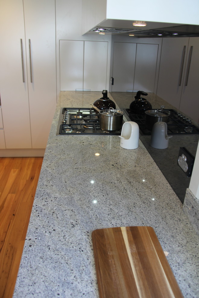 Immagine di una cucina minimalista con top in granito