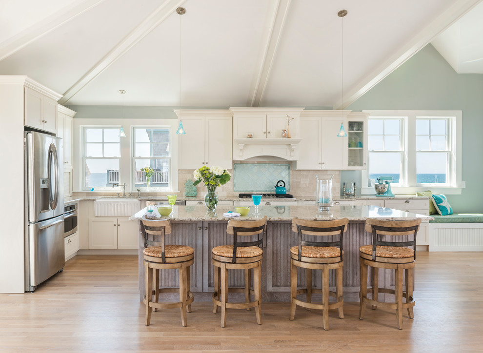 Maritime Küche in L-Form mit Landhausspüle, Schrankfronten im Shaker-Stil, beigen Schränken, Küchenrückwand in Blau, Küchengeräten aus Edelstahl, hellem Holzboden und Kücheninsel in Providence