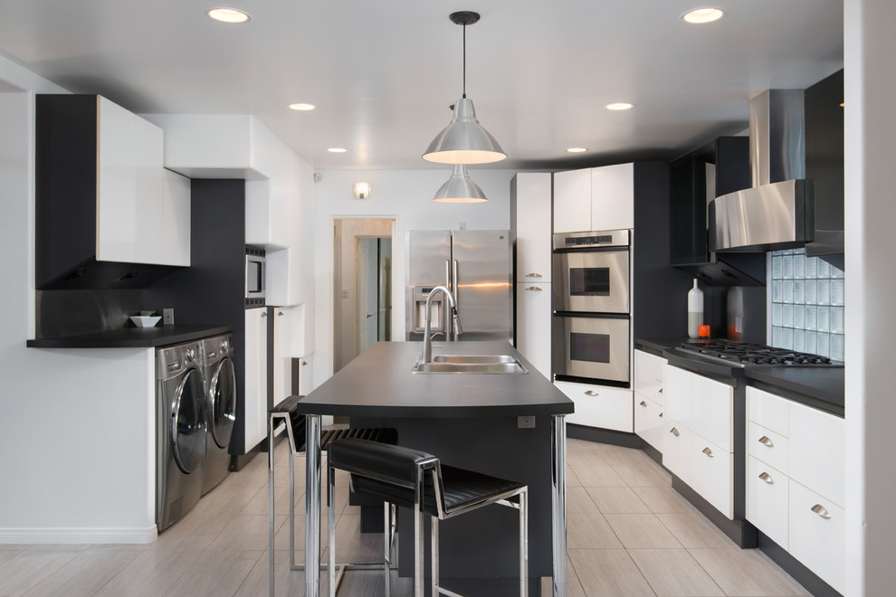 Moderne Küche mit flächenbündigen Schrankfronten, Küchengeräten aus Edelstahl, Kücheninsel und Doppelwaschbecken in San Diego