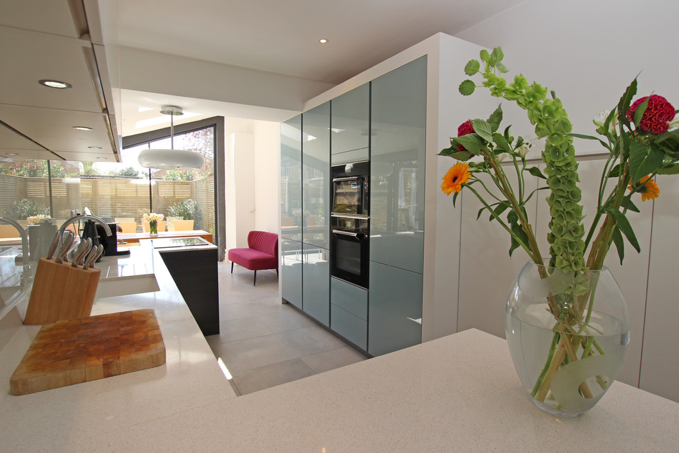 Cette photo montre une cuisine moderne avec un plan de travail en quartz modifié et une crédence grise.