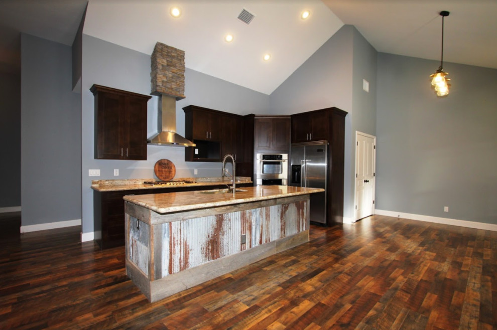 Exempel på ett mellanstort rustikt l-kök, med skåp i shakerstil, skåp i mörkt trä, granitbänkskiva, rostfria vitvaror, mellanmörkt trägolv, en köksö och brunt golv