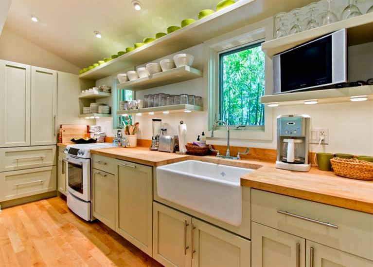 Ejemplo de cocina lineal contemporánea pequeña abierta con fregadero sobremueble, armarios estilo shaker, puertas de armario grises, encimera de madera, electrodomésticos con paneles, suelo de madera clara y una isla
