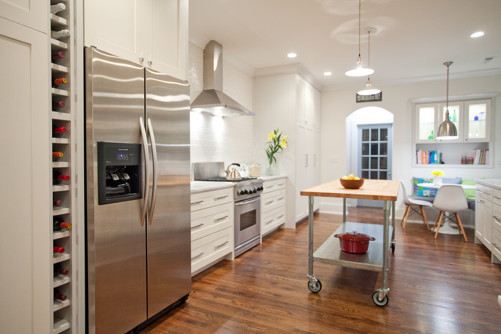 ニューヨークにある高級な広いコンテンポラリースタイルのおしゃれなキッチン (アンダーカウンターシンク、シェーカースタイル扉のキャビネット、白いキャビネット、大理石カウンター、白いキッチンパネル、シルバーの調理設備、無垢フローリング) の写真