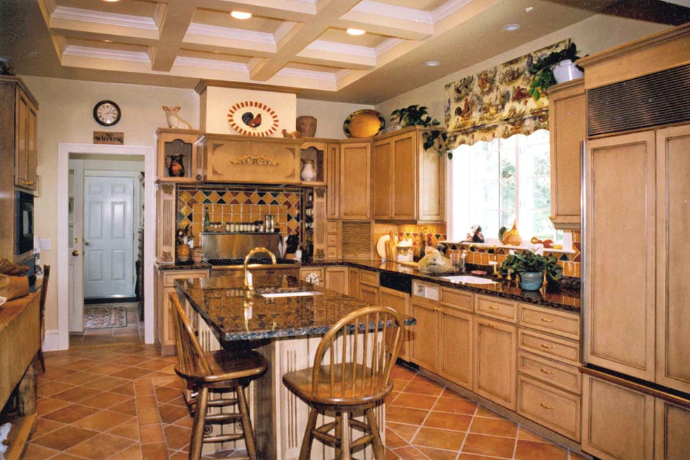 Klassisk inredning av ett stort kök, med en undermonterad diskho, luckor med infälld panel, skåp i mellenmörkt trä, granitbänkskiva, stänkskydd i keramik, integrerade vitvaror, klinkergolv i keramik, en köksö och brunt golv