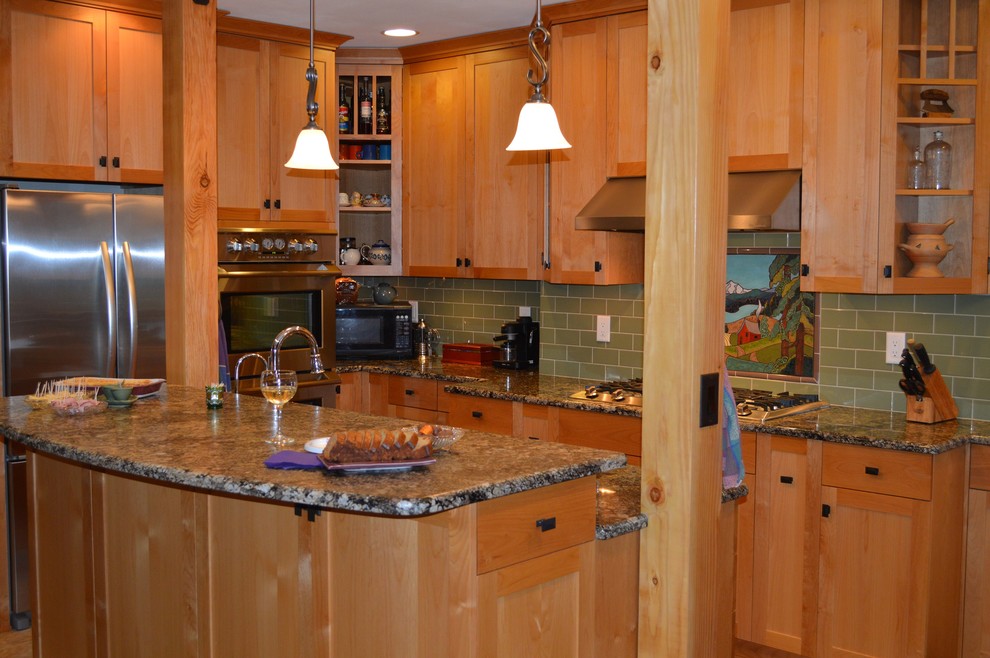 Cette image montre une petite cuisine craftsman en U et bois clair avec un placard à porte shaker et îlot.