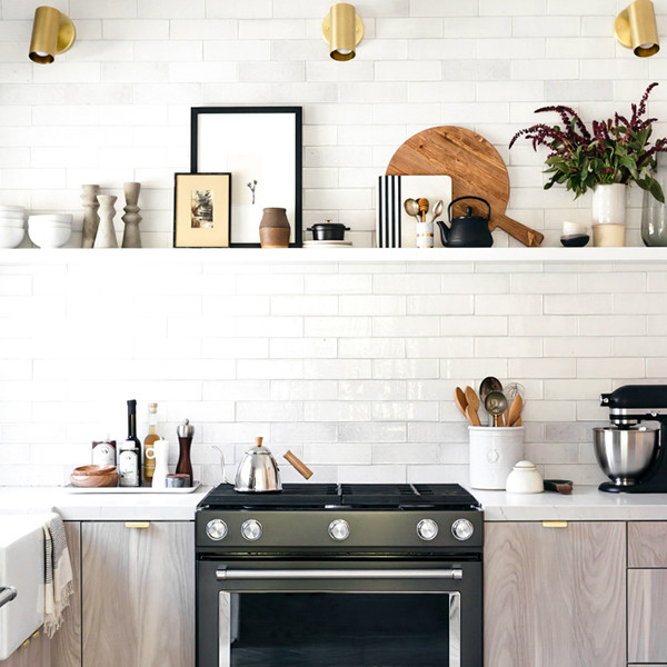 Foto di una cucina ad U scandinava con ante lisce, ante in legno chiaro, top in quarzo composito e elettrodomestici neri
