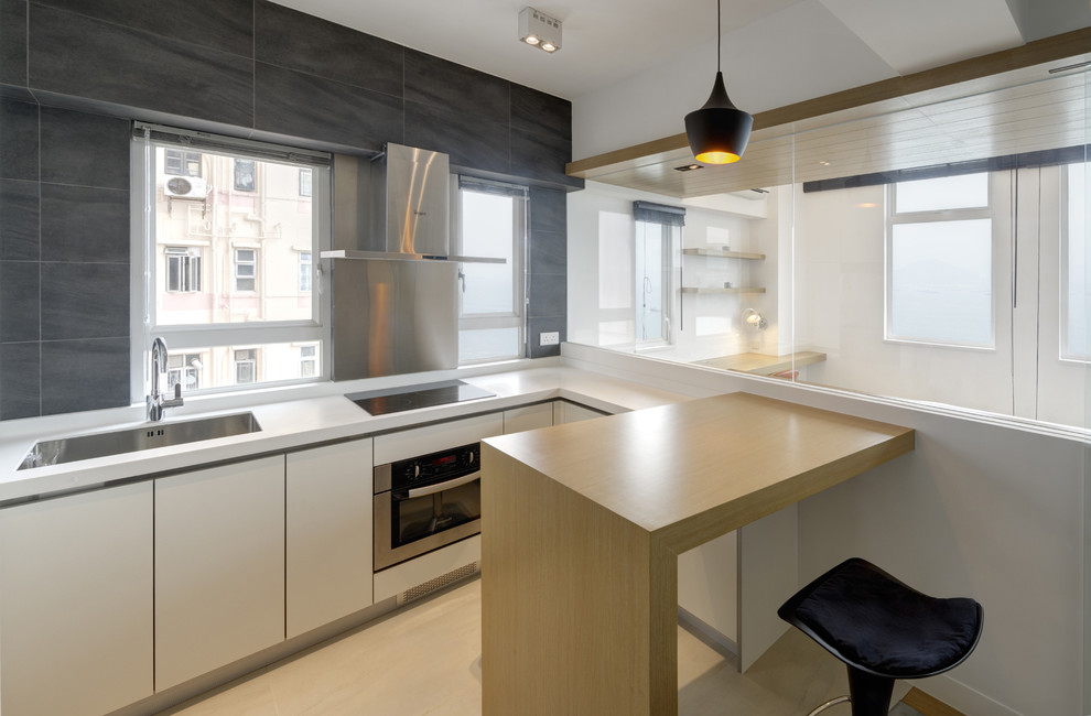 Idéer för ett modernt kök, med en undermonterad diskho, släta luckor, vita skåp, grått stänkskydd och rostfria vitvaror