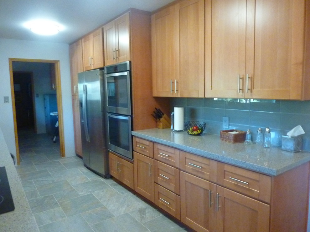 Exempel på ett mellanstort amerikanskt kök, med en undermonterad diskho, skåp i shakerstil, skåp i ljust trä, bänkskiva i kvarts, blått stänkskydd, stänkskydd i glaskakel, rostfria vitvaror, klinkergolv i keramik och grått golv