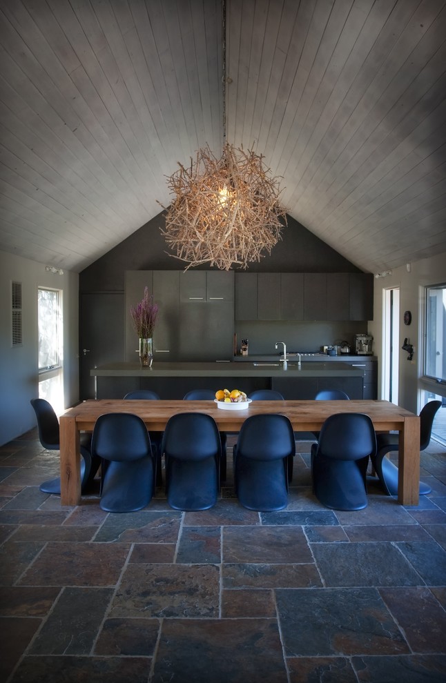 Свежая идея для дизайна: большая параллельная кухня-гостиная в современном стиле с плоскими фасадами, темными деревянными фасадами, полом из сланца и островом в частном доме - отличное фото интерьера