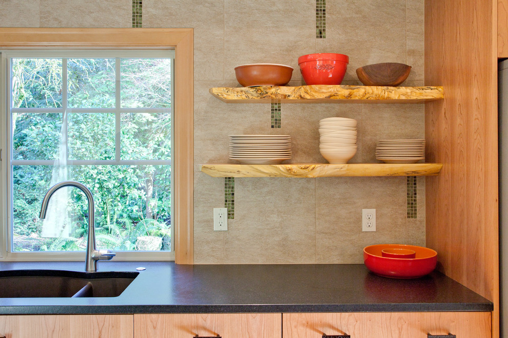 Exempel på ett litet modernt kök, med en undermonterad diskho, släta luckor, skåp i mellenmörkt trä, granitbänkskiva, beige stänkskydd, stänkskydd i porslinskakel, rostfria vitvaror, bambugolv och en köksö