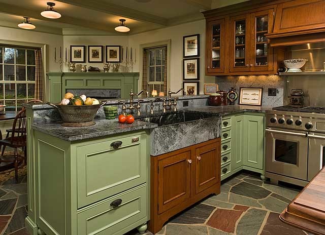 Inredning av ett klassiskt stort linjärt kök, med en rustik diskho, luckor med profilerade fronter, gröna skåp, bänkskiva i täljsten, grått stänkskydd, stänkskydd i sten, integrerade vitvaror, skiffergolv och en köksö