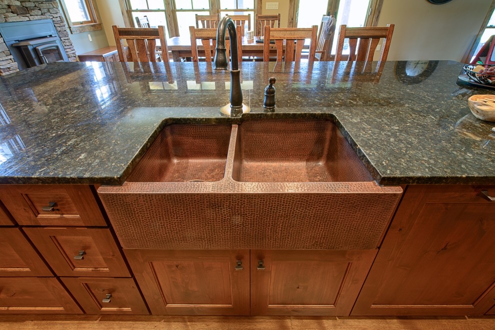 Example of a cottage u-shaped medium tone wood floor eat-in kitchen design in Charleston with a farmhouse sink, recessed-panel cabinets, distressed cabinets, granite countertops, green backsplash, porcelain backsplash, stainless steel appliances and an island