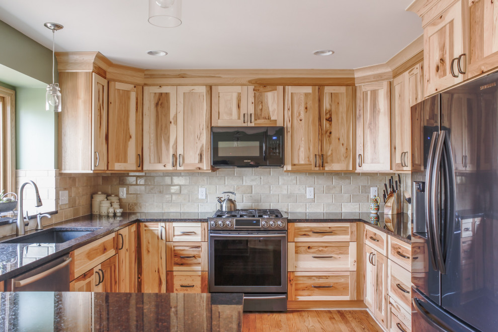 Bild på ett mellanstort rustikt svart svart kök, med en undermonterad diskho, luckor med infälld panel, skåp i ljust trä, bänkskiva i kvarts, beige stänkskydd, stänkskydd i travertin, rostfria vitvaror, ljust trägolv, en halv köksö och brunt golv