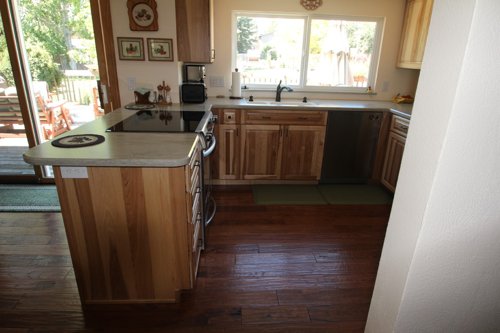Kleine Urige Wohnküche in U-Form mit integriertem Waschbecken, profilierten Schrankfronten, hellen Holzschränken, Mineralwerkstoff-Arbeitsplatte, Küchengeräten aus Edelstahl, dunklem Holzboden und Halbinsel in Denver
